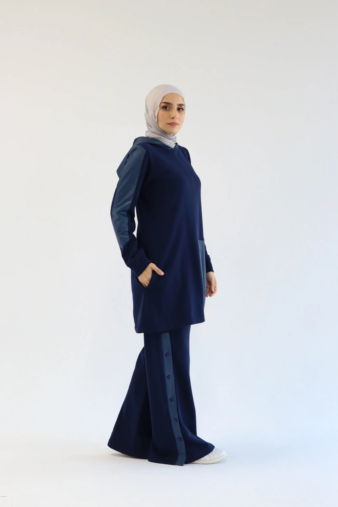 Woman wearing a navy blue outfit with a hijab on a white background