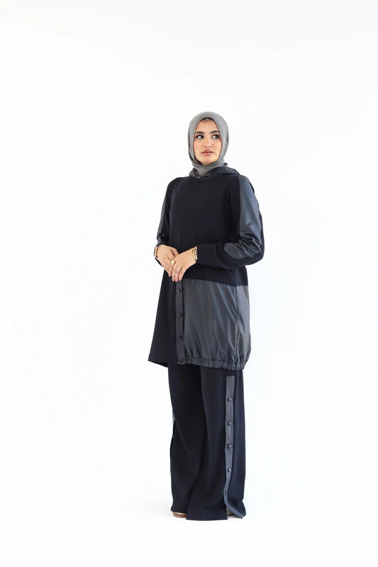 Woman wearing a black outfit with a gray hijab on a white background