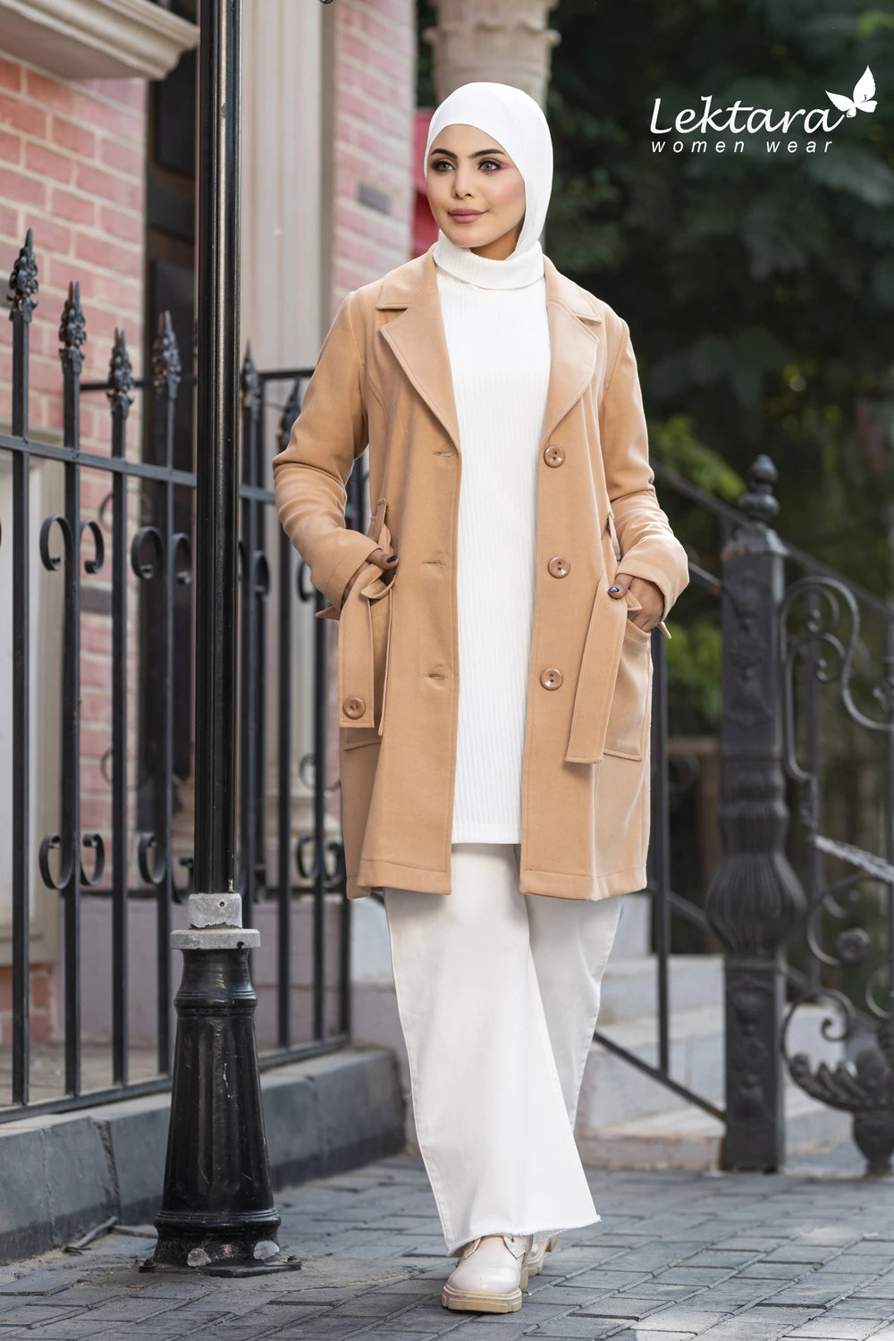 Woman wearing a beige Structured Wool Belted Jacket and white hijab walking on a sidewalk with 'Lektara Women Wear' branding.