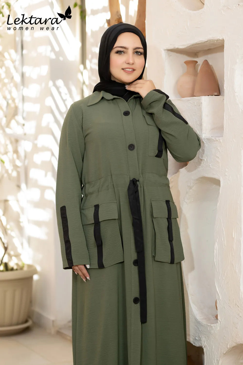 Olive green modest maxi dress with waist tie, button-front closure and long sleeves, styled for modern modest fashion