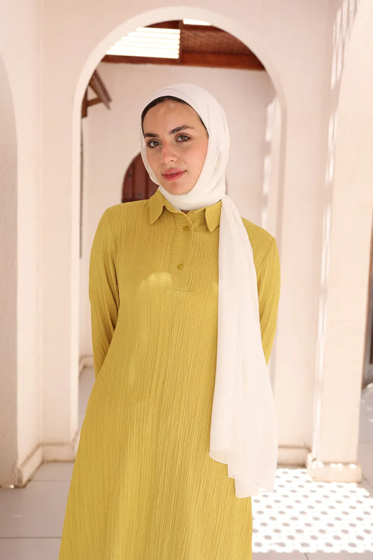 Yellow modest dress worn by hijabi model standing front view