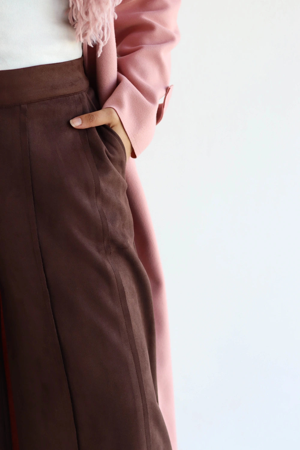 Brown pants with a pink coat on a light background