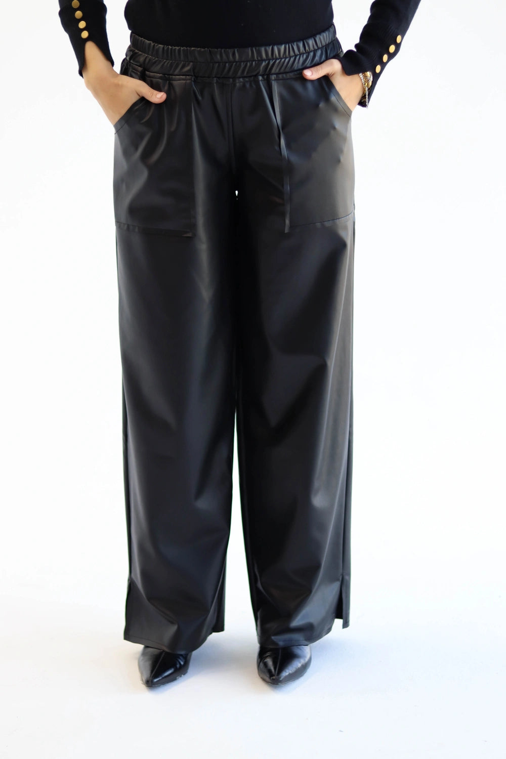 Person wearing black leather pants on a white background
