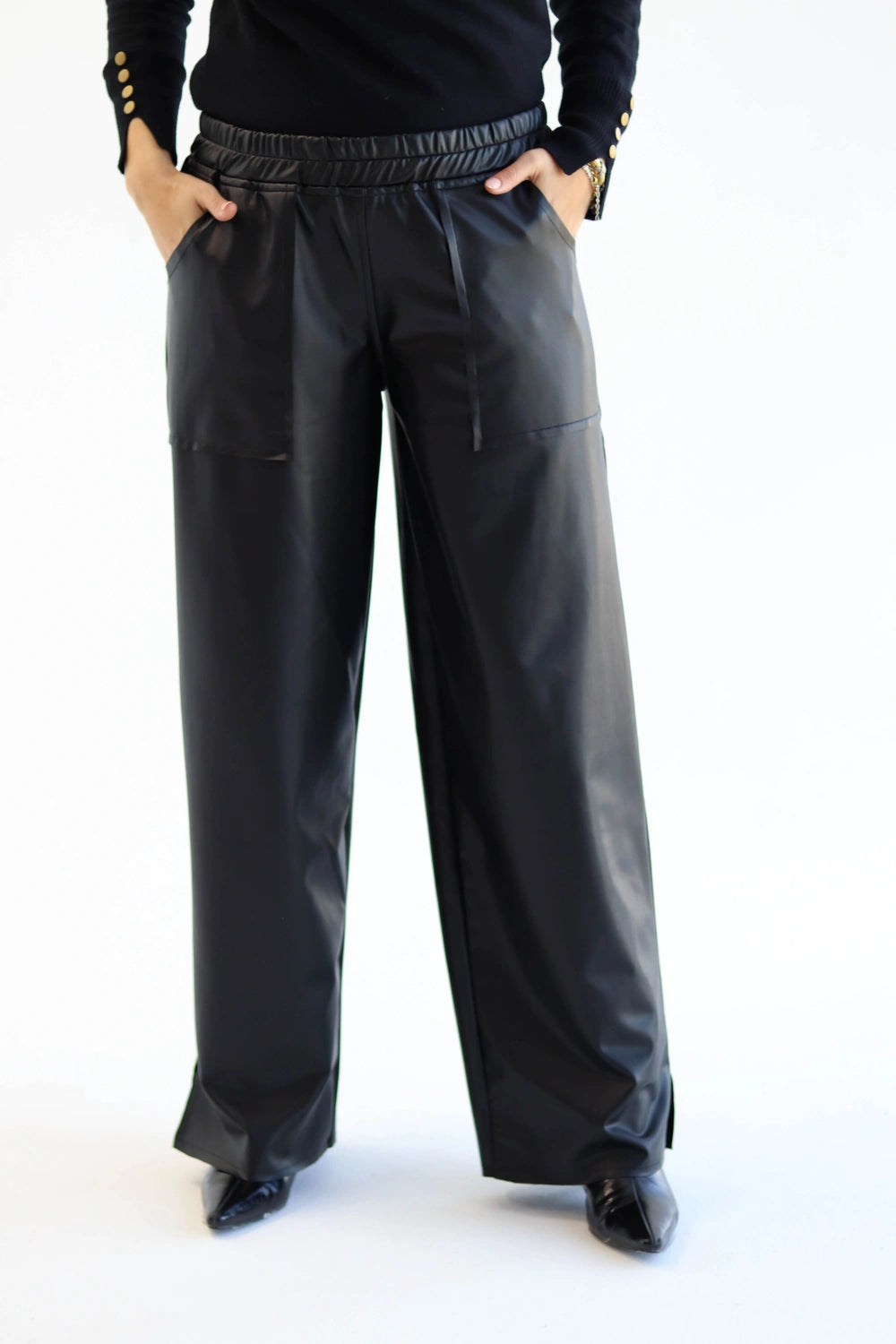 Black leather pants worn by a person on a white background