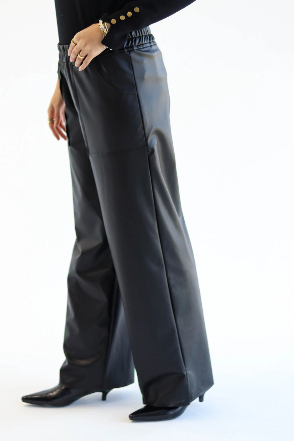 Person wearing black leather pants on a white background