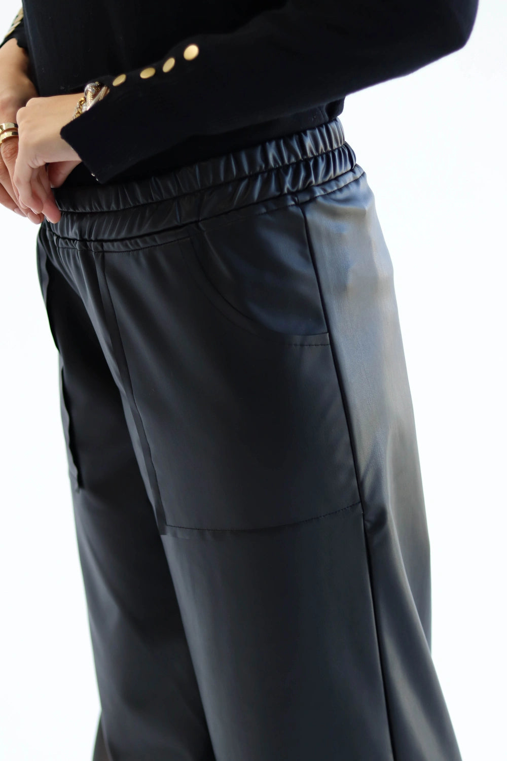 Dark  pants worn by a person on a white background