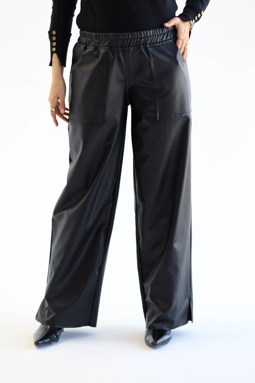 Person wearing black leather pants on a white background