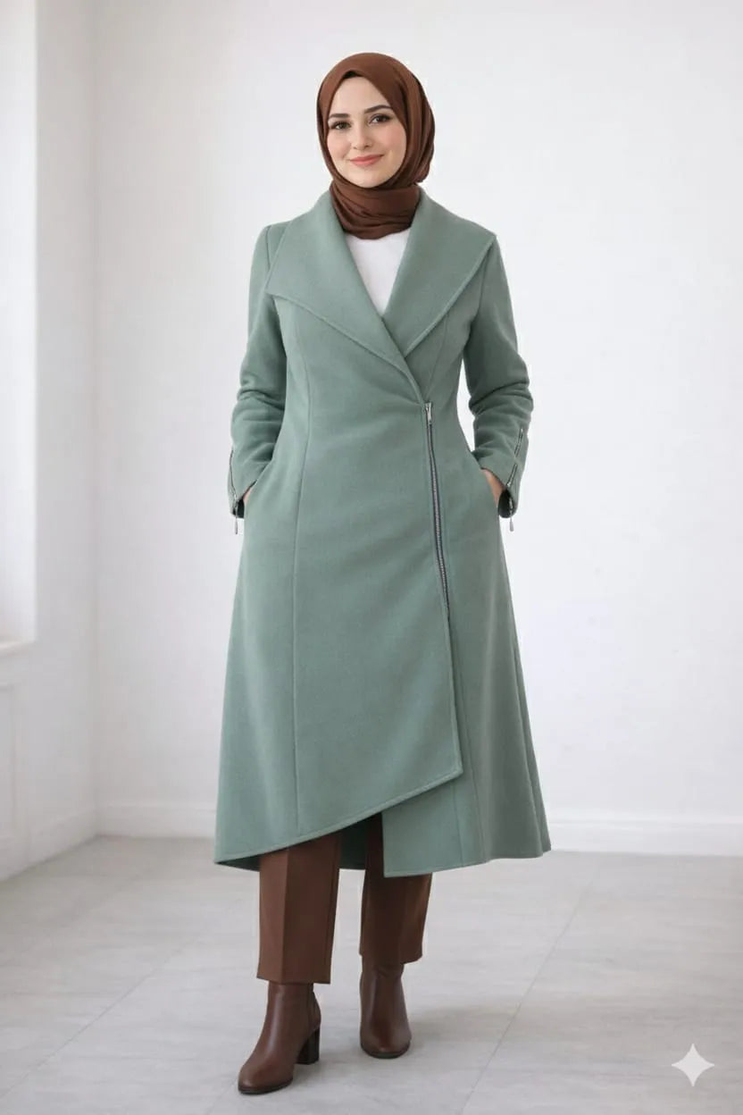 Woman wearing a long green coat and brown hijab on a white background