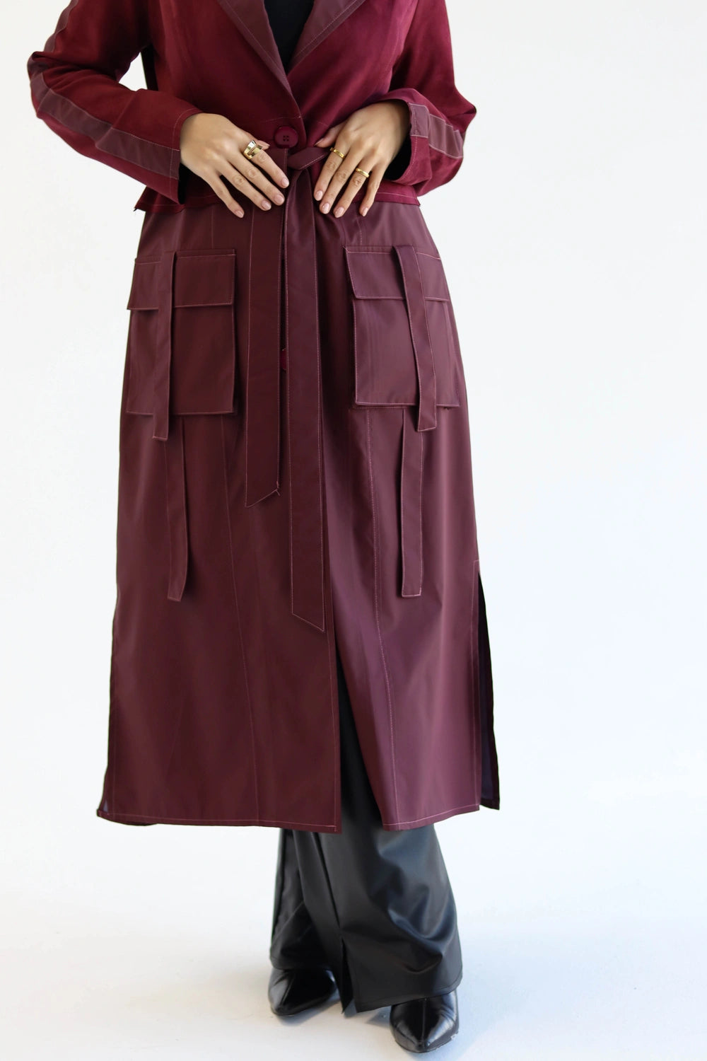 Maroon trench coat worn by a woman in hijab on a white background