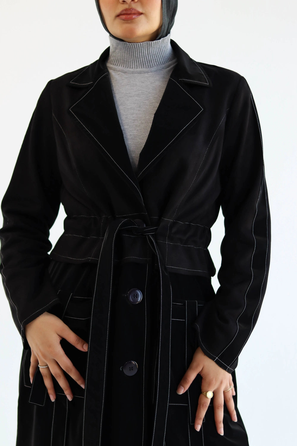 Woman  in hijab  wearing a black  suede coat with a white background