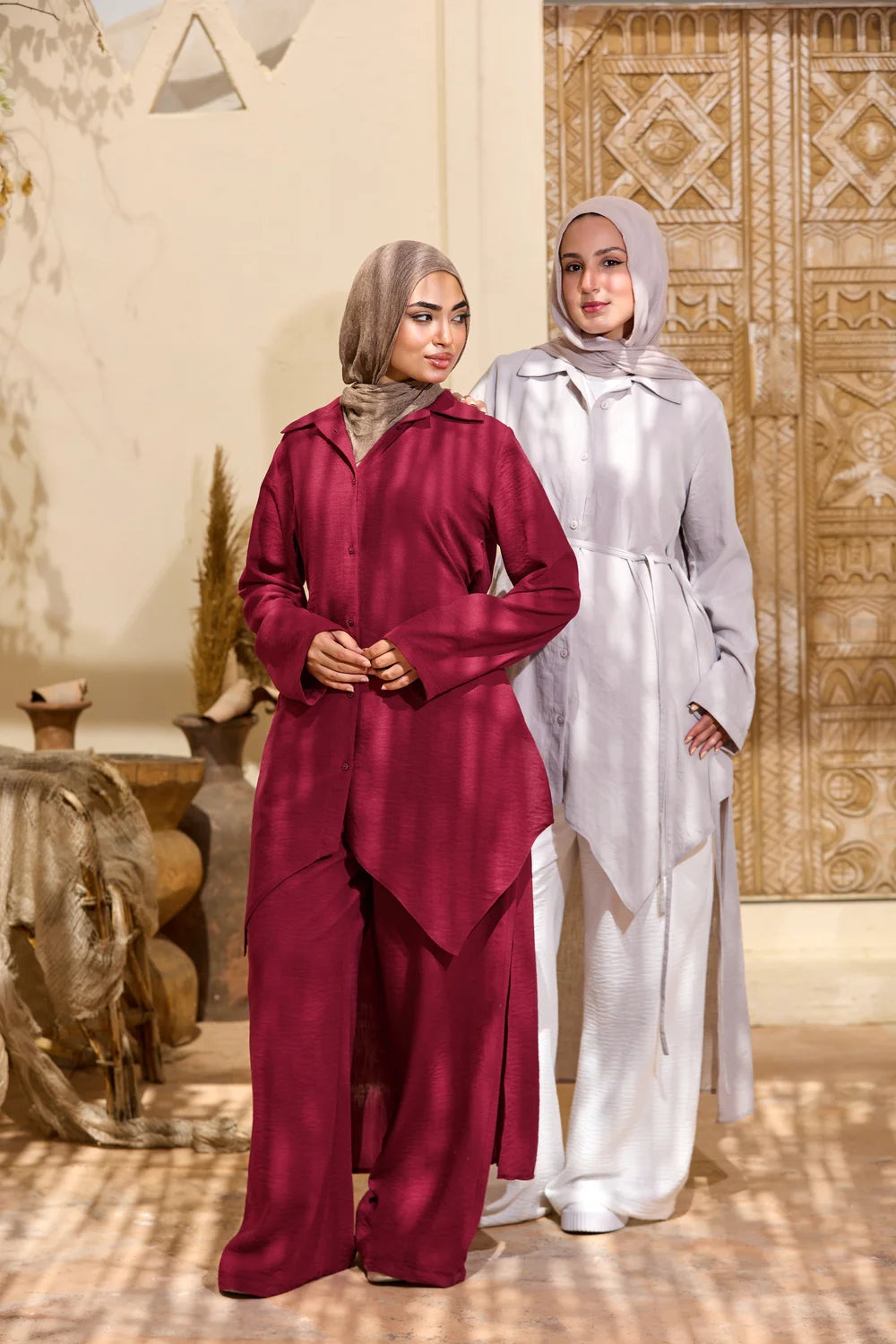 Two models wearing burgundy and light grey High-Low Triangle Hem Tunics in a full-length view