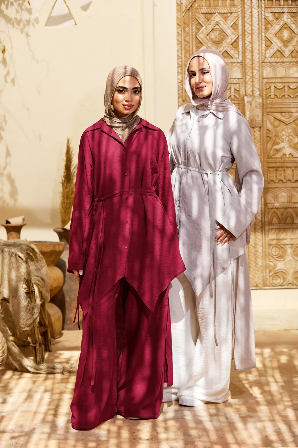 Two models posing in burgundy and light grey High-Low Triangle Hem Tunics with wide-leg trousers