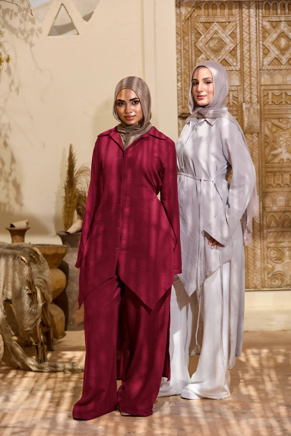 Two models wearing burgundy and light grey High-Low Triangle Hem Tunics with wide-leg trousers
