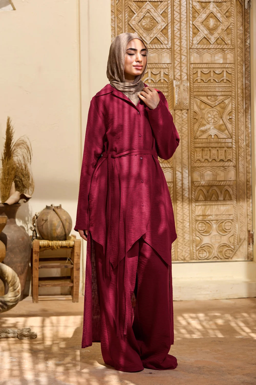 Side profile of the burgundy High-Low Triangle Hem Tunic showing the drape and longer back