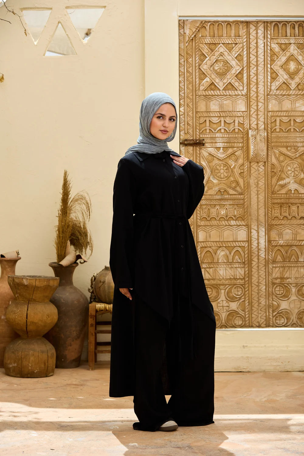 Front view of the black High-Low Triangle Hem Tunic showing the waist ties and flowing shape