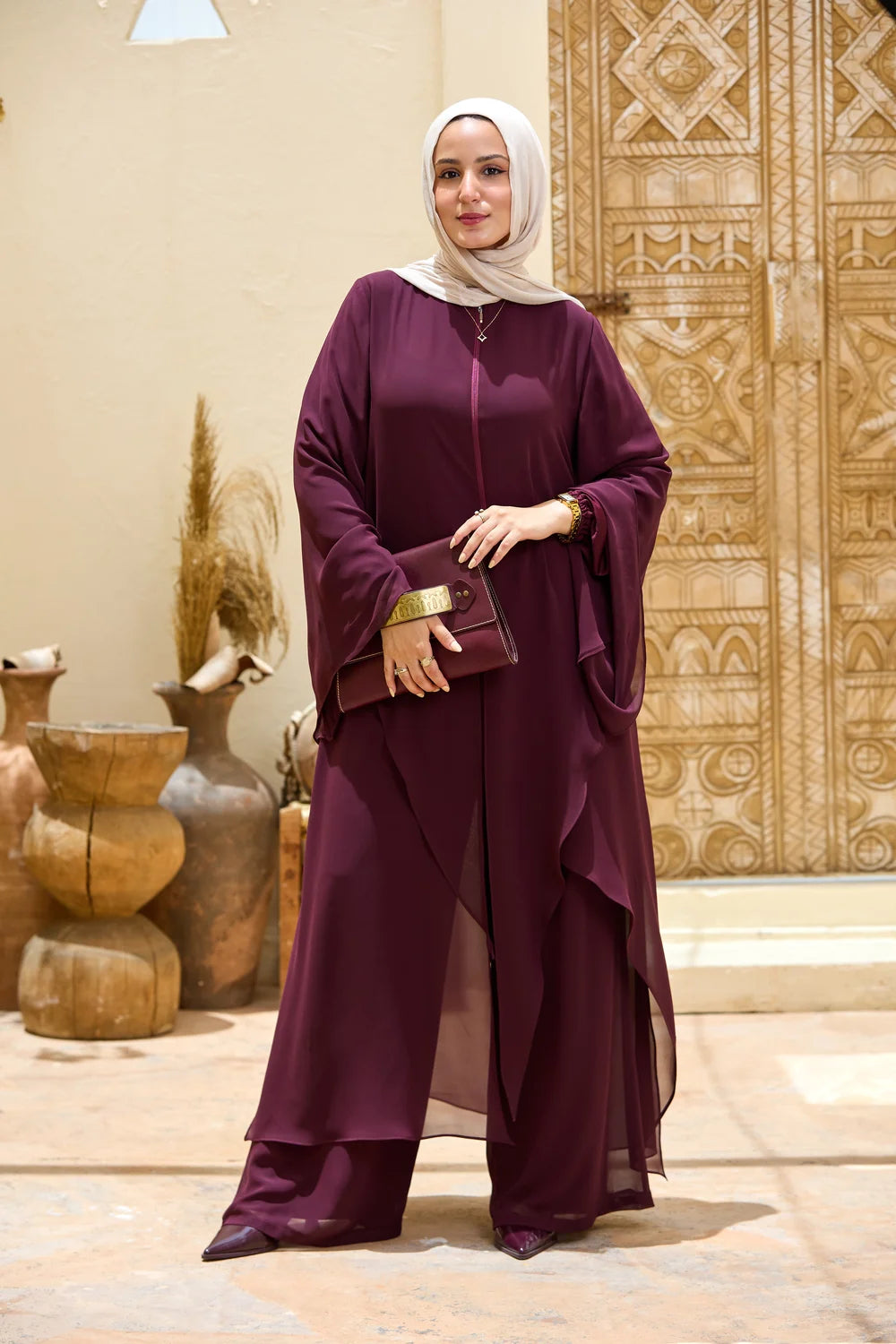 Front view of the deep purple Layered Chiffon Triangle Hem Tunic styled with wide-leg trousers and a clutch