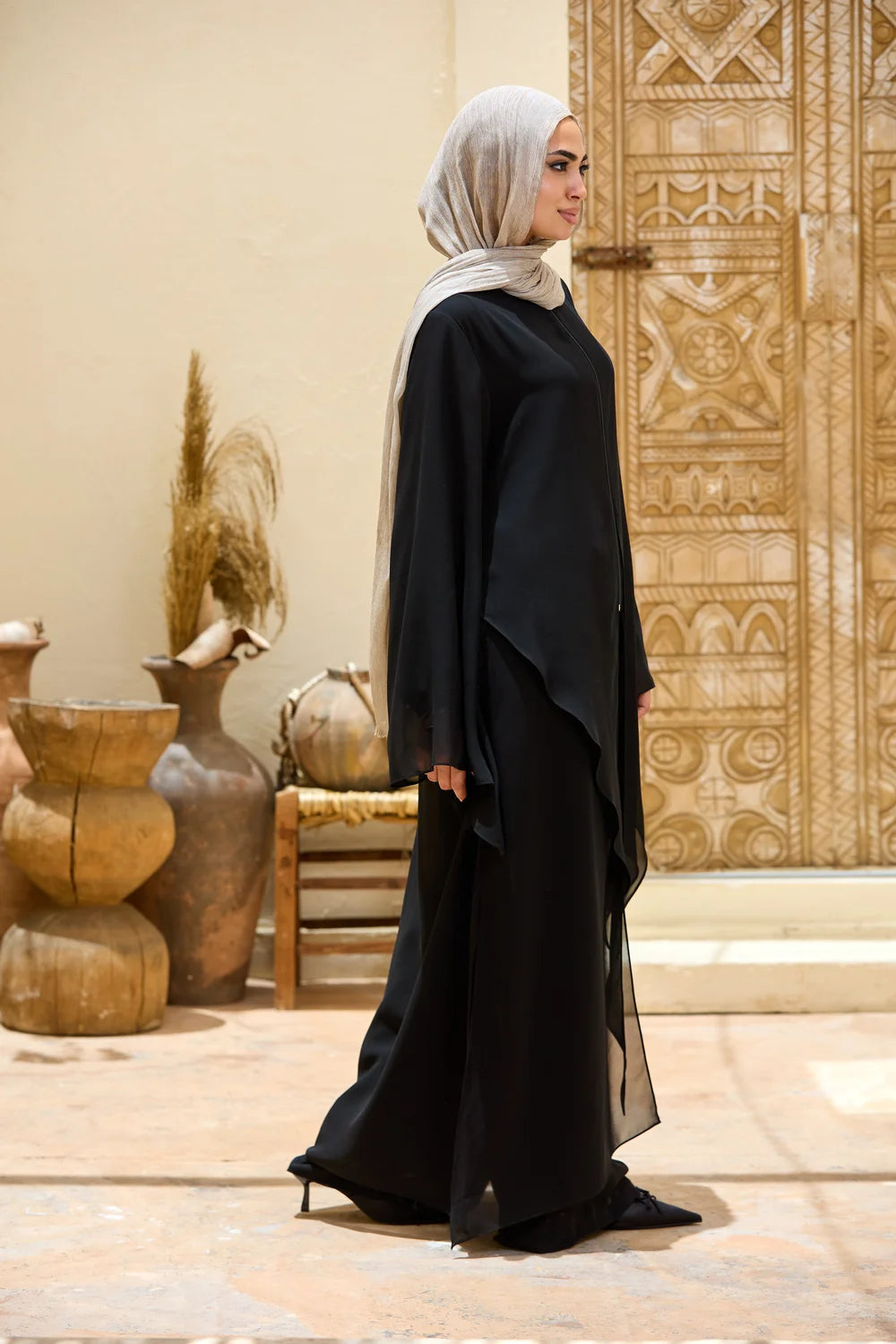 Back three-quarter view of the black chiffon tunic showing the long straight-cut back