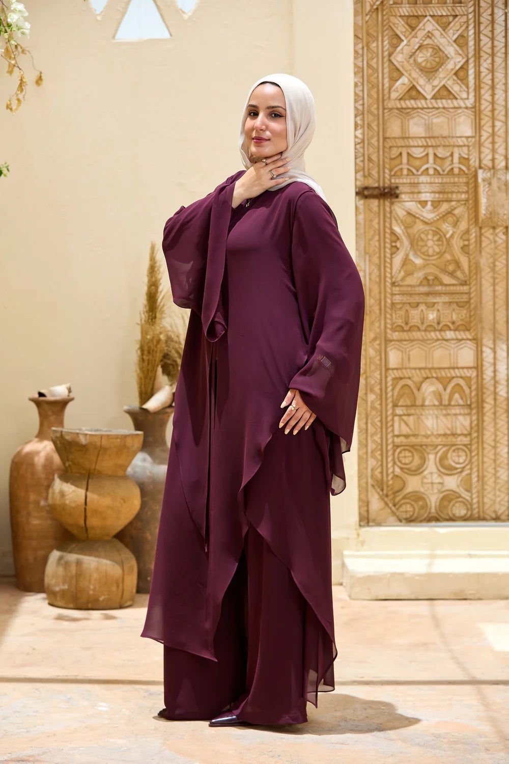 Side view of the deep purple Layered Chiffon Triangle Hem Tunic showing the long straight back and layered sleeve
