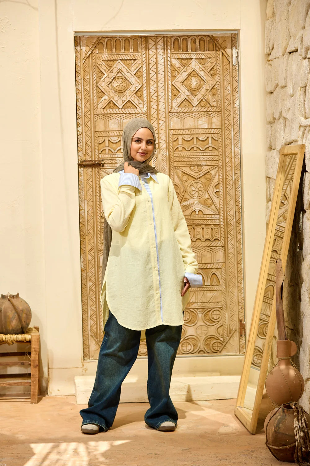Full-length front view of the baby yellow Linen Shirt styled with wide-leg jeans