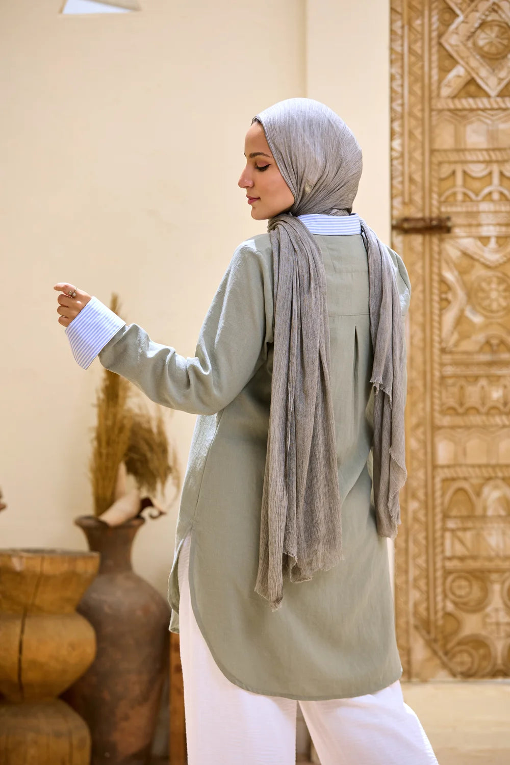 Back three-quarter view of the army green Linen Shirt showing the curved back hem