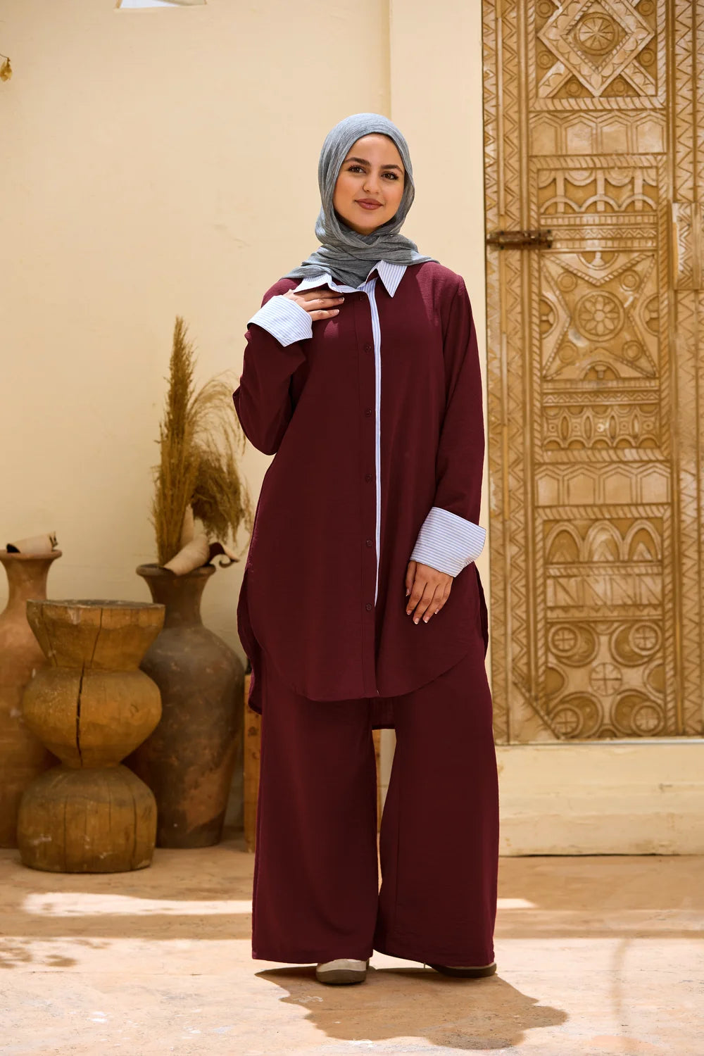 Full-length front view of the burgundy Linen Shirt showing its relaxed fit and curved hem