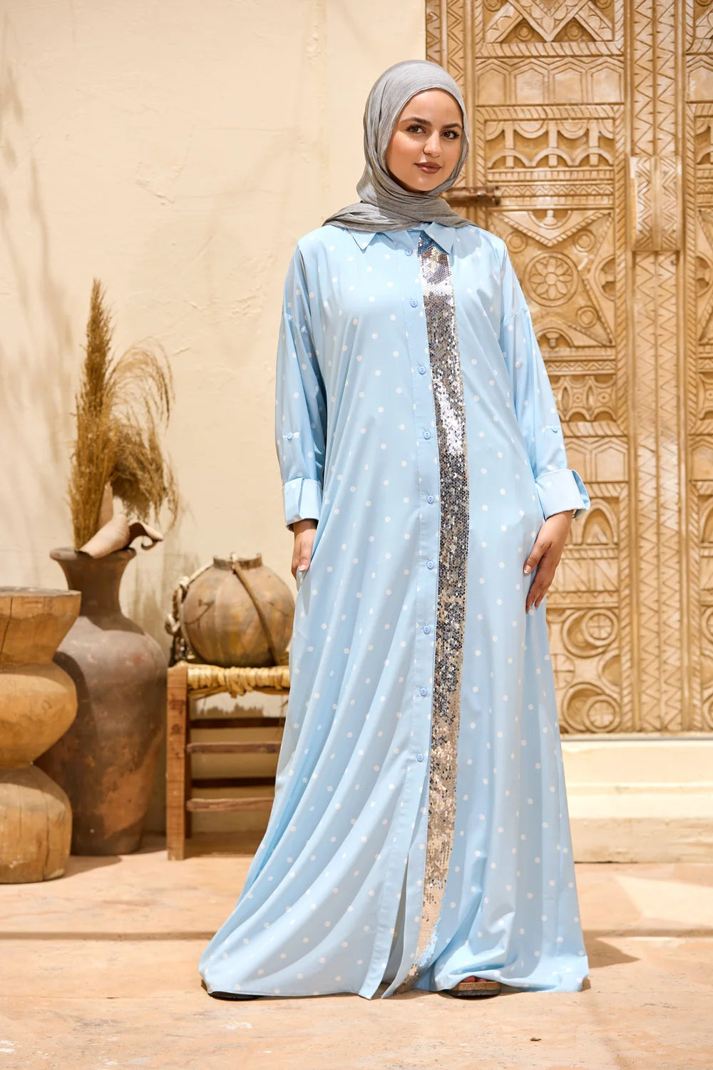 Woman wearing a baby blue polka dot maxi shirt dress with a sequin front panel, full-length front view