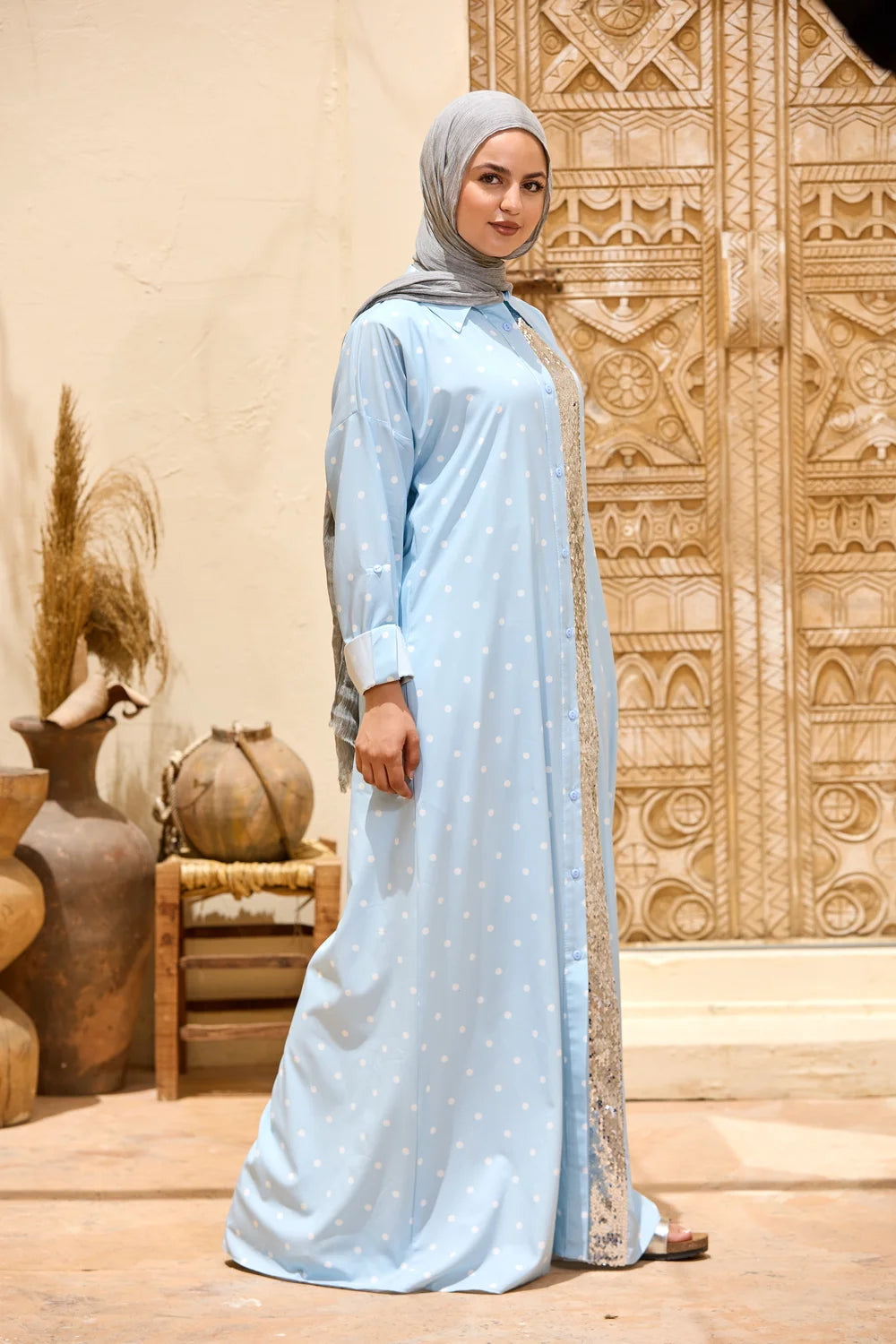 Woman in a baby blue polka dot maxi shirt dress with a sequin front panel, full-length three-quarter view