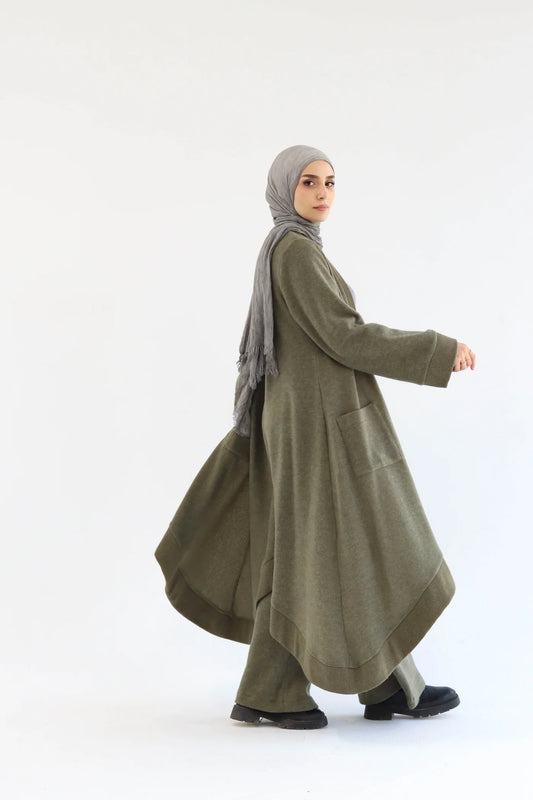 Side view of olive cardigan set highlighting layered silhouette and flowing knit fabric.