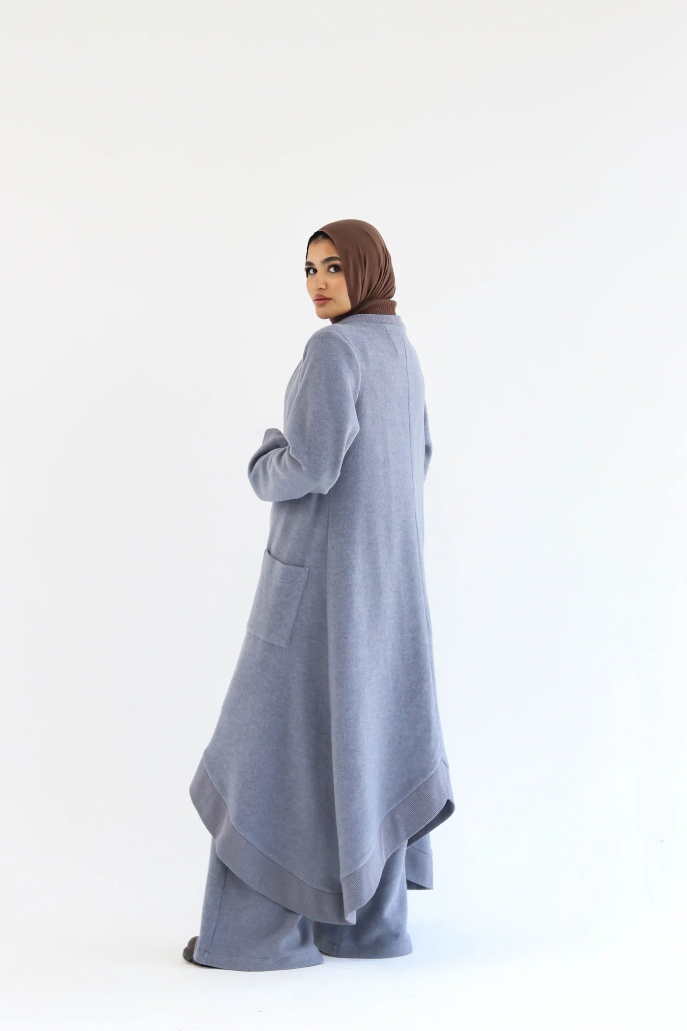 Blue knitted cardigan set side view showing length, drape, and relaxed silhouette.