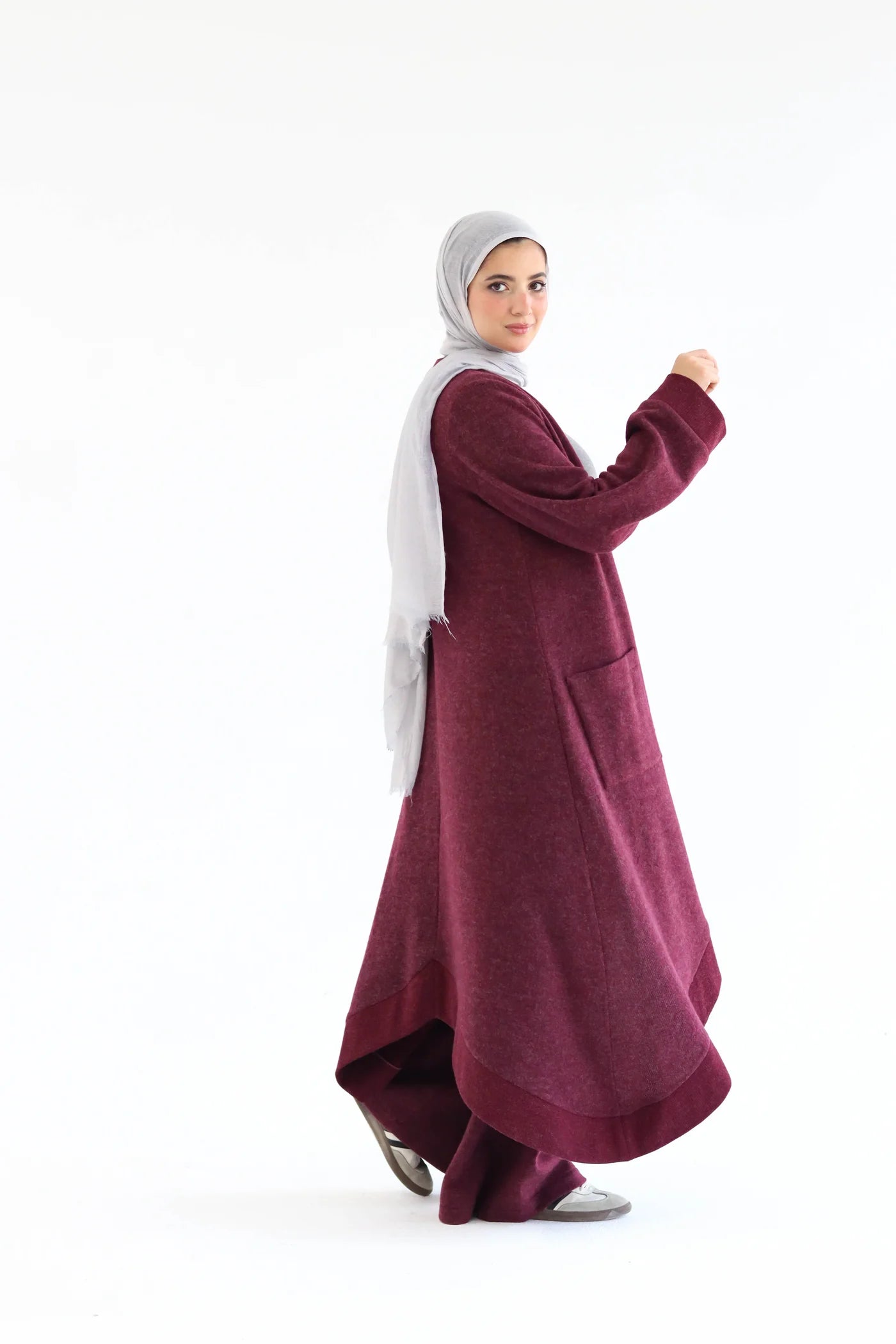 Burgundy cardigan set captured in motion, showing flowing open cardigan and wide-leg pants while walking.