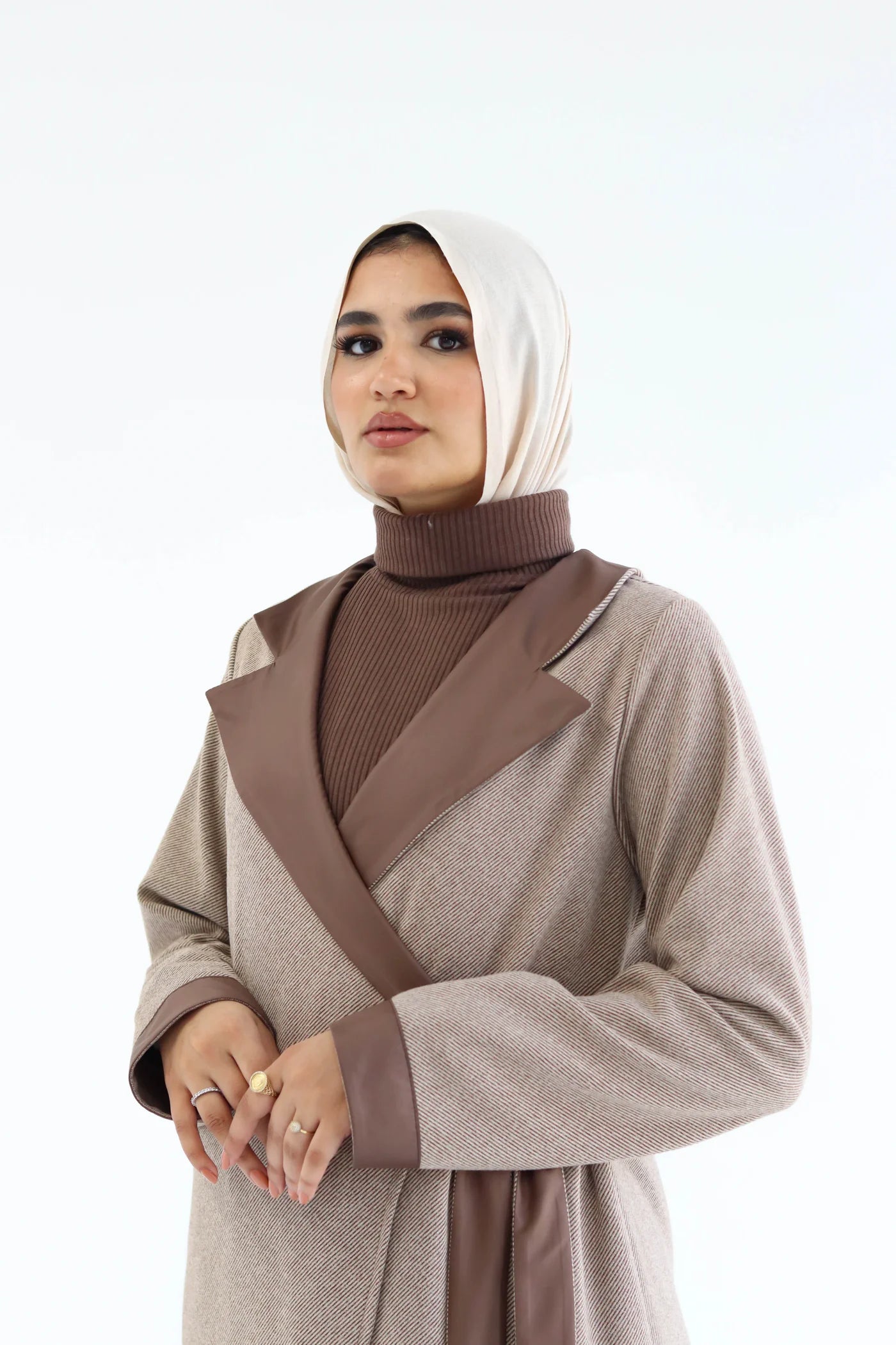 Woman wearing a brown and beige outfit with a headscarf on a white background