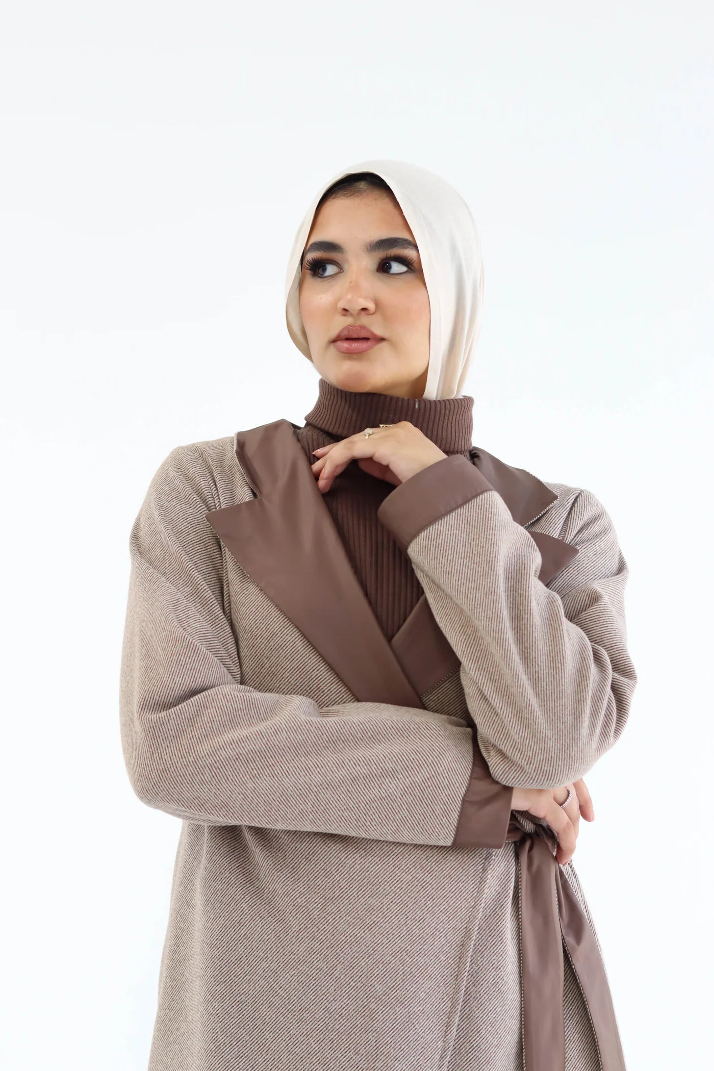 Woman wearing a beige and brown outfit with a matching hijab on a white background