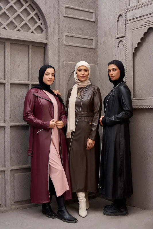 Three women wearing modest coat dresses in burgundy, brown, and black — group style photo