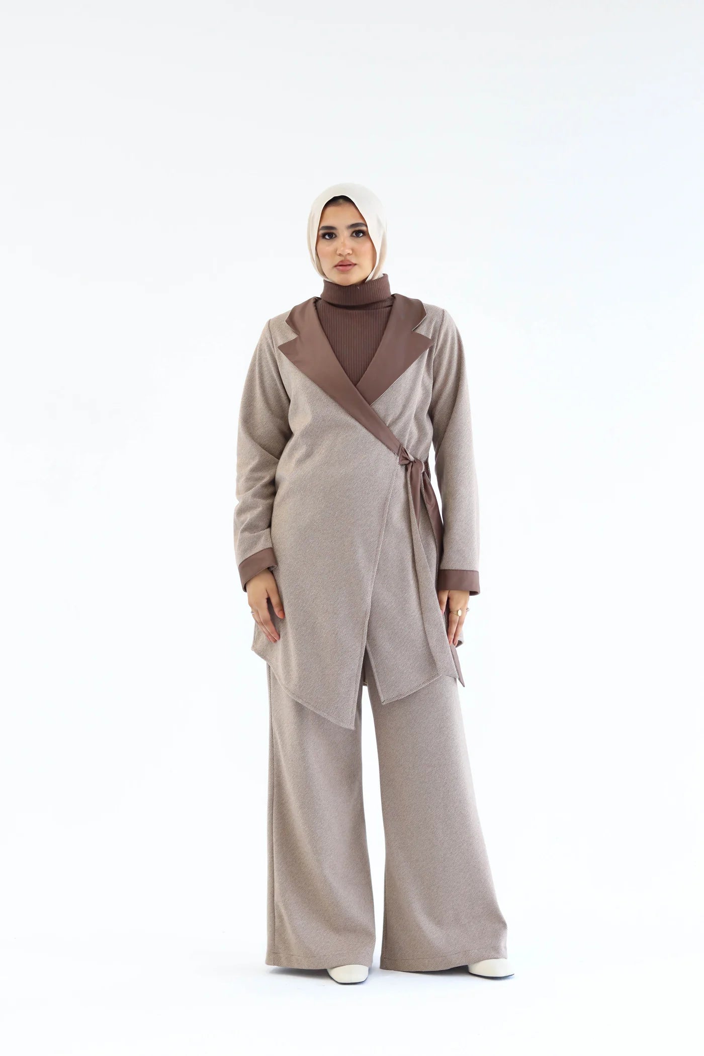Beige two-piece wrap set featuring an asymmetric wrap top with diagonal overlap and wide-leg pants, full-length front view.