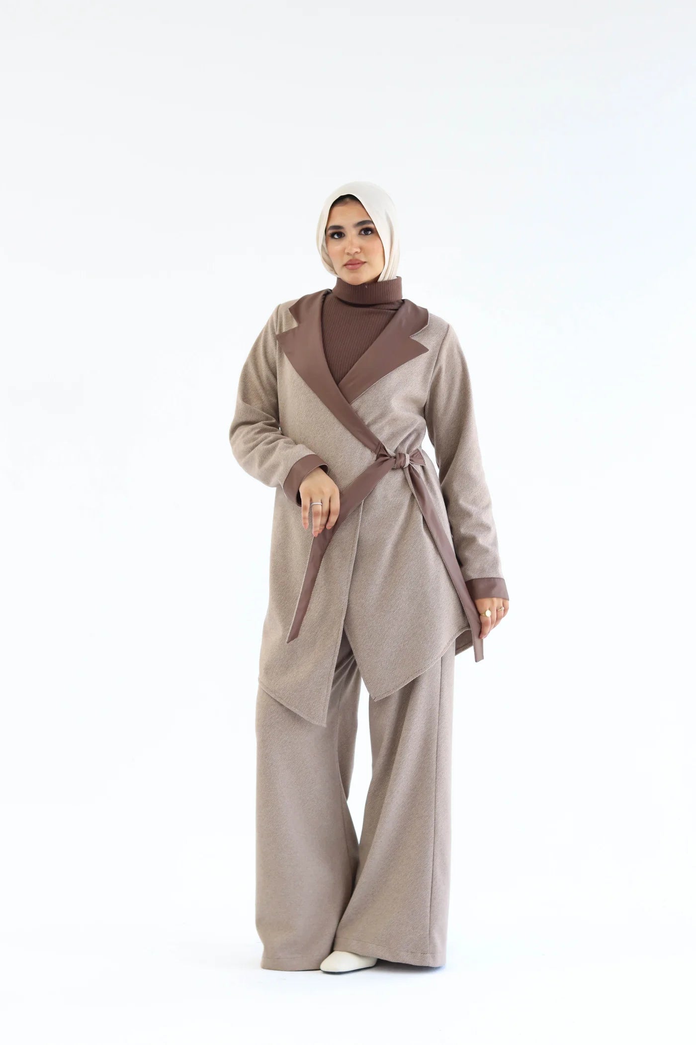Beige two-piece wrap set with soft asymmetric wrap top and wide-leg pants, full-length view while walking.