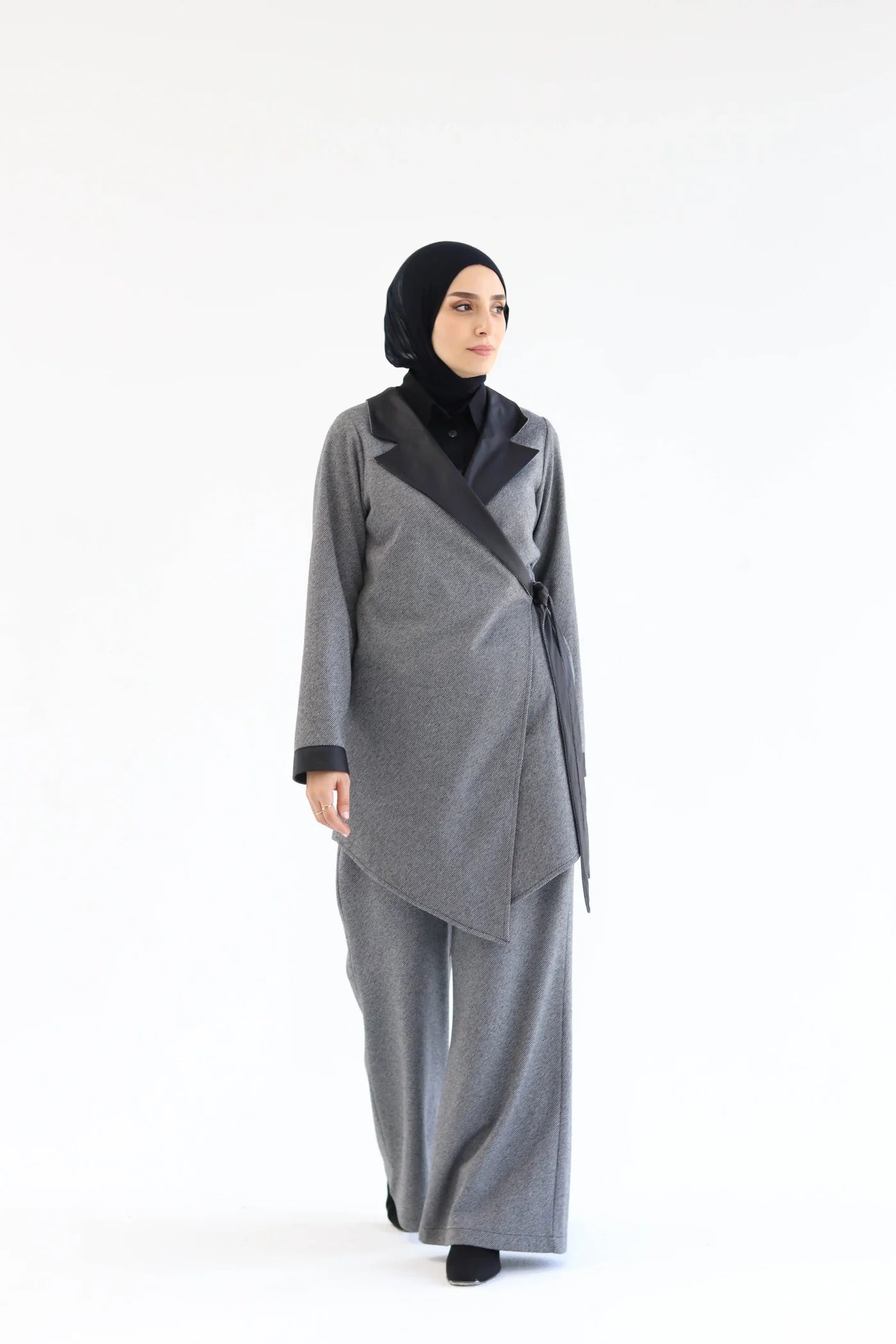 Grey two-piece wrap set with layered asymmetric wrap top and wide-leg pants, full-length view with slight body turn.