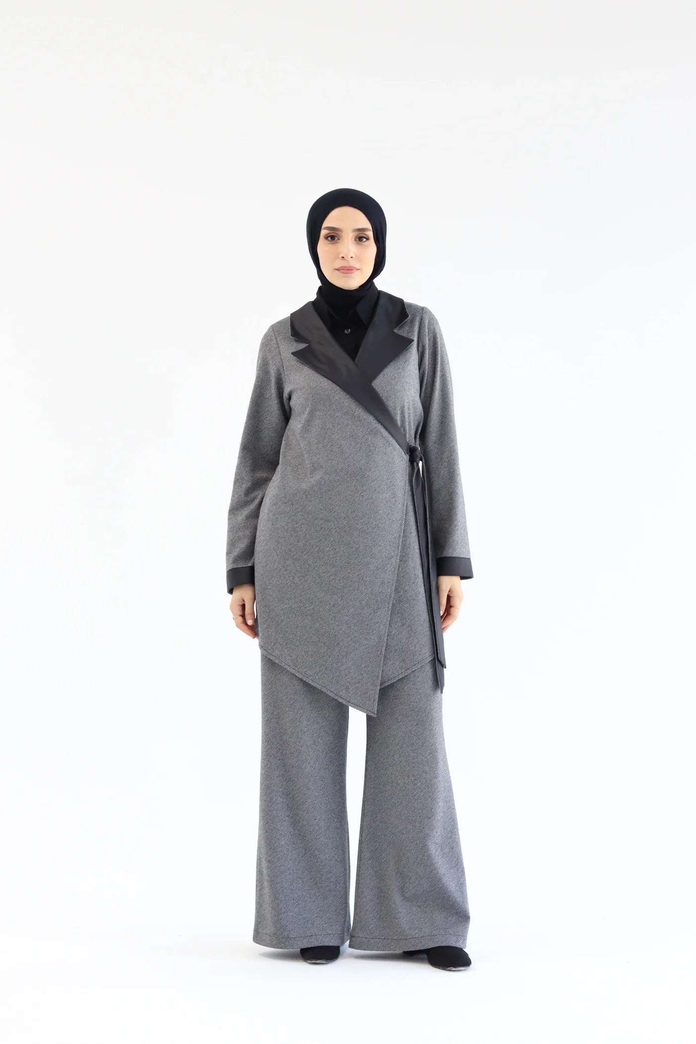 Grey two-piece wrap set with asymmetric wrap top, long sleeves, and wide-leg pants, front view with hands clasped.
