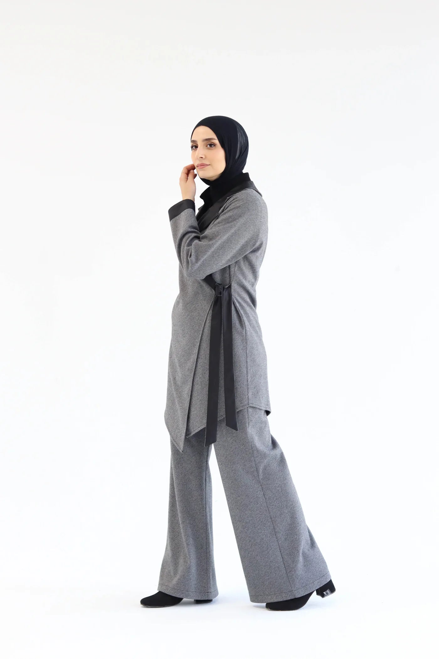 Side view of a grey two-piece wrap set showing the asymmetric wrap construction, long sleeves, and wide-leg pants.